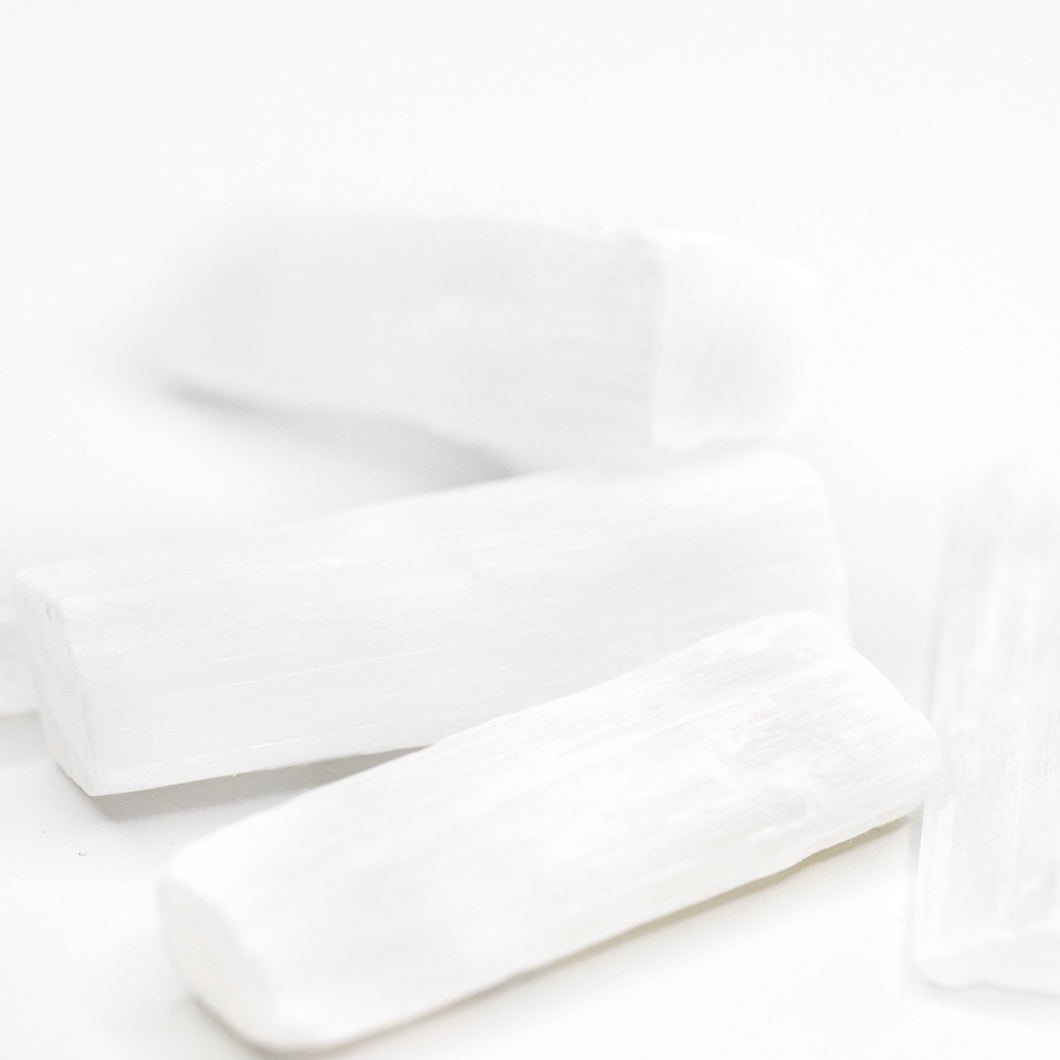Polished white Selenite sticks shown together on a white background; listing includes one stick with a meaning card and organza bag.